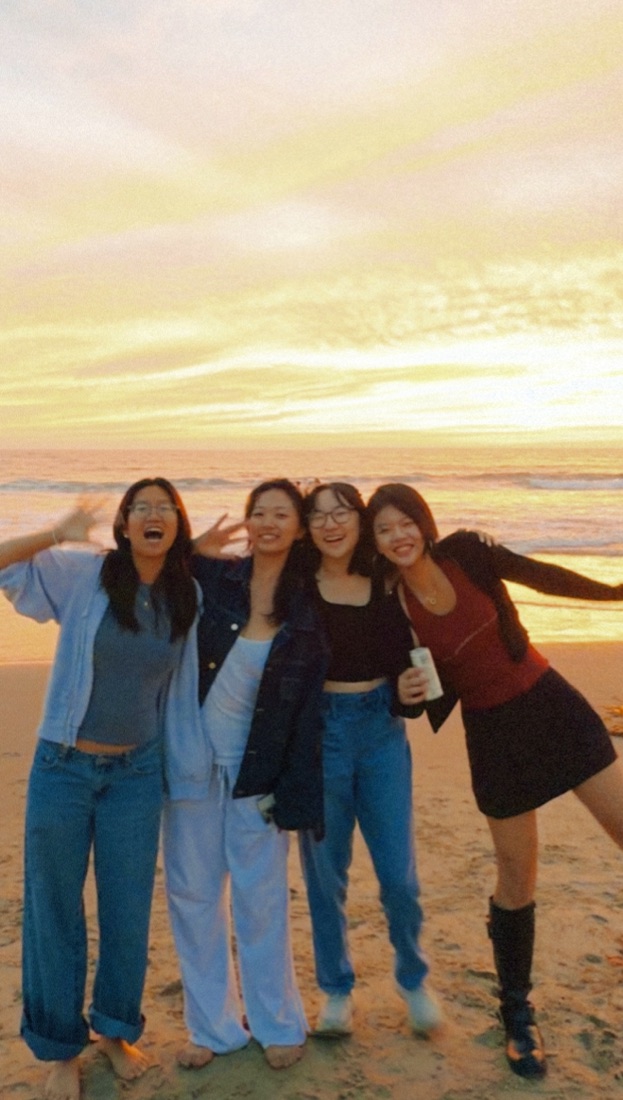 Four friends on the beach at sunset